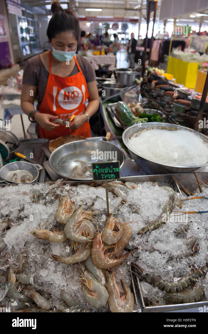 Cooks cooking Thai seafood dishes at a stall in Or Tor Gor market in Bangkok. Stock Photo