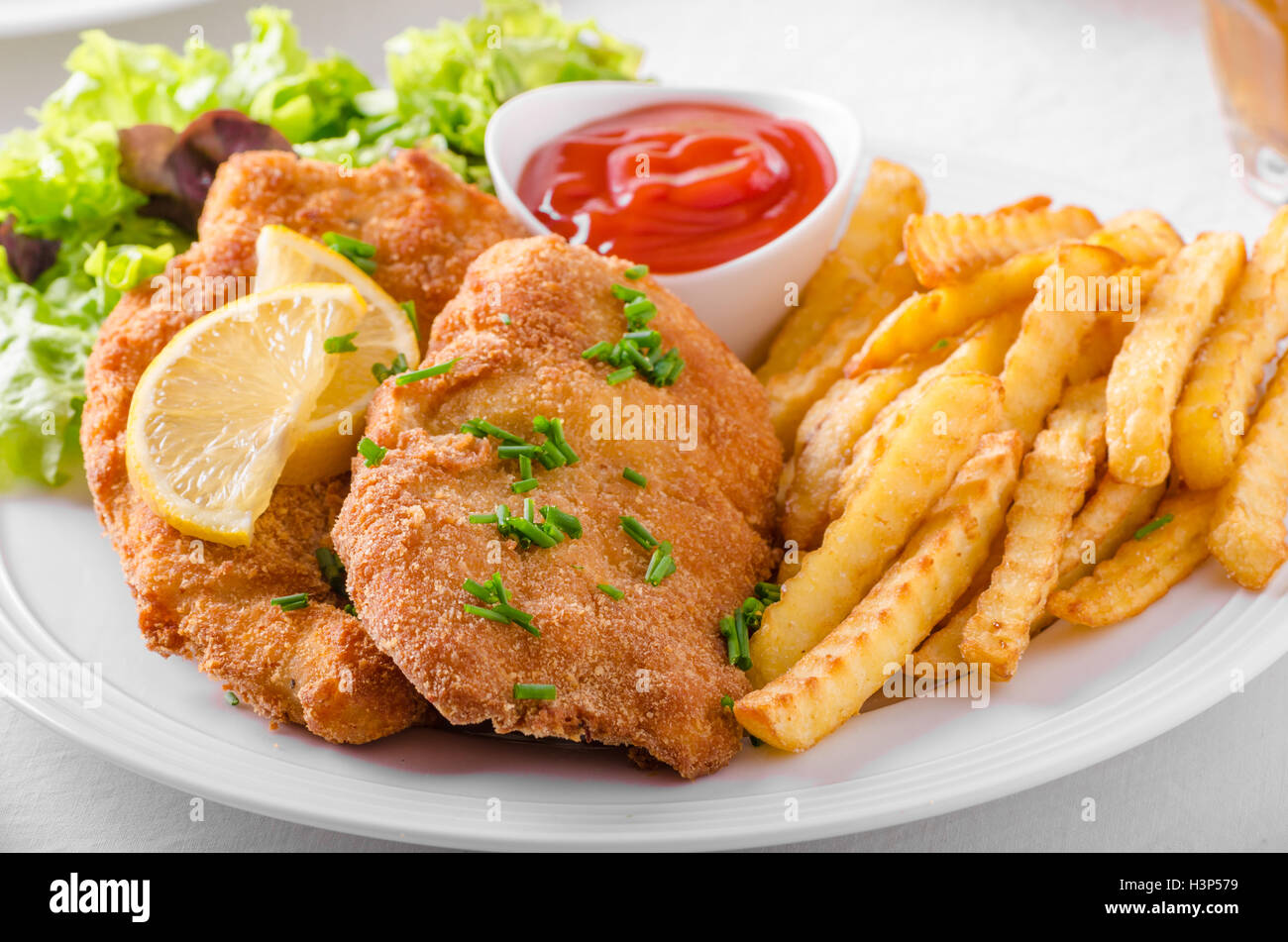 Wiener schnitzel with french fries, salad and a sharp dip Stock Photo ...