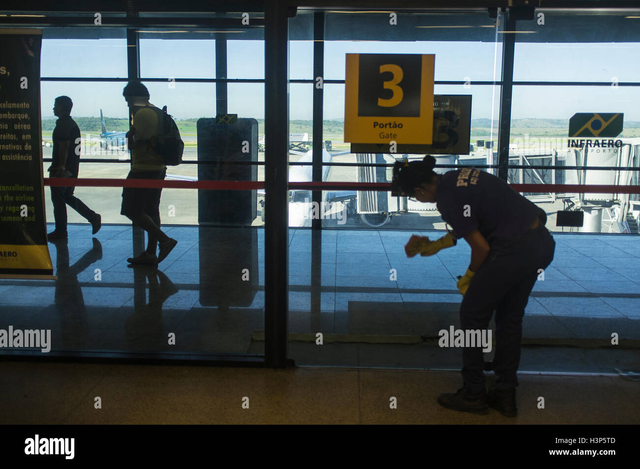 Cleaning lady cleans pane at Belo Horizonte international airport