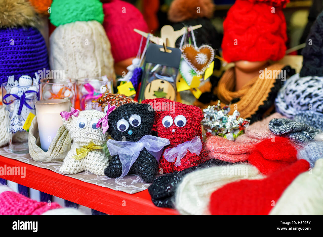 Cute little cat toys among other knitted warm clothes at the stand during the Christmas market