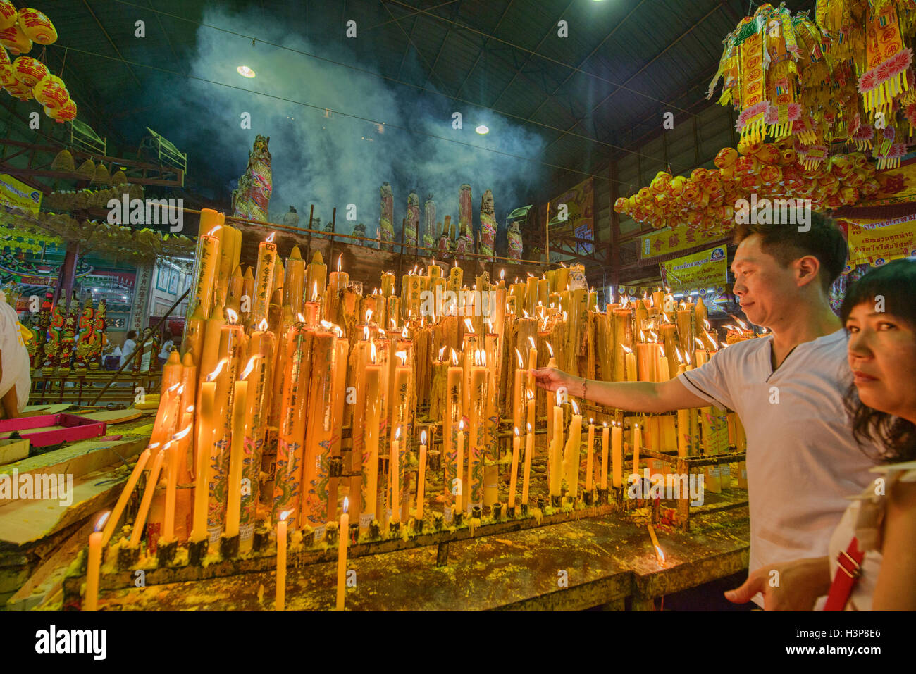 lighting candles for good luck at the Vegetarian Festival in Bangkok