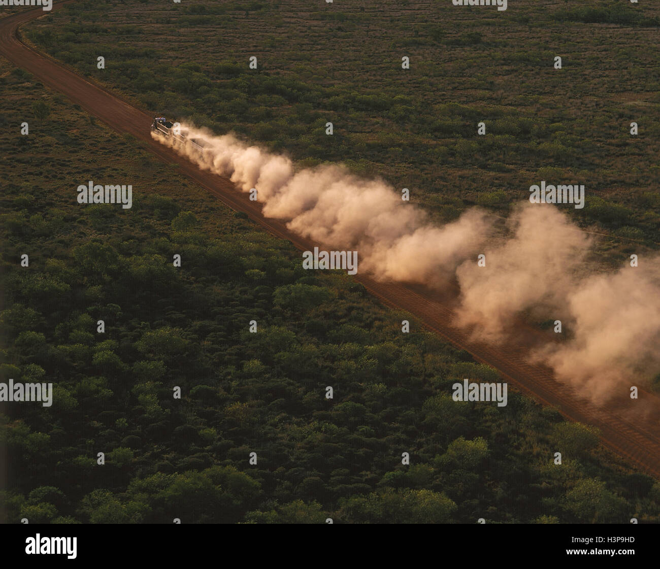 Road train carrying mineral ore on a dirt road, aerial. Stock Photo