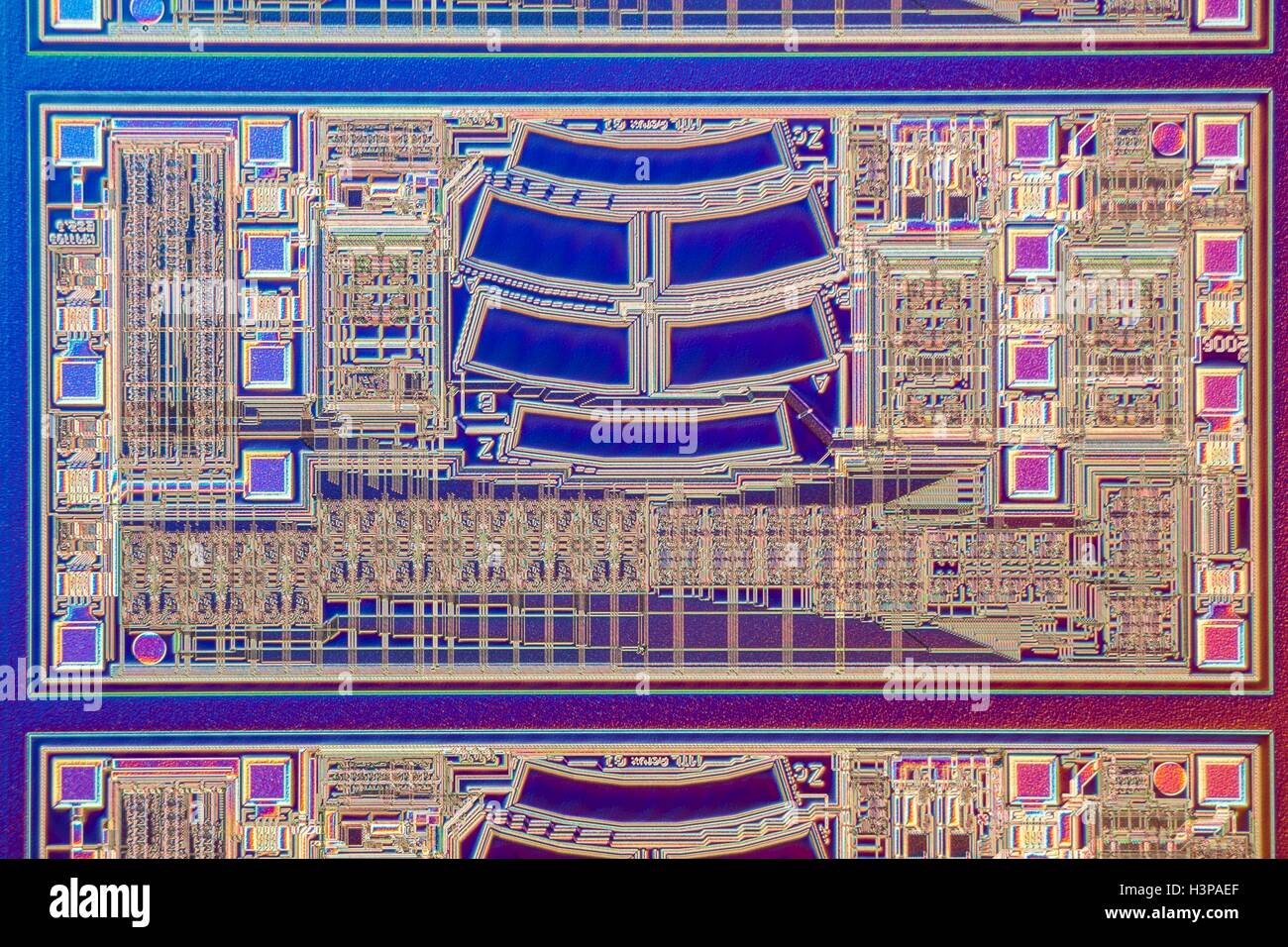 Computer chip. Light micrograph taken with episcopic lighting and Normarski Interference Contrast (DIC) of a detail of a microchip on a silicon wafer. Horizontal object size of this section: 0.6 mm. Stock Photo
