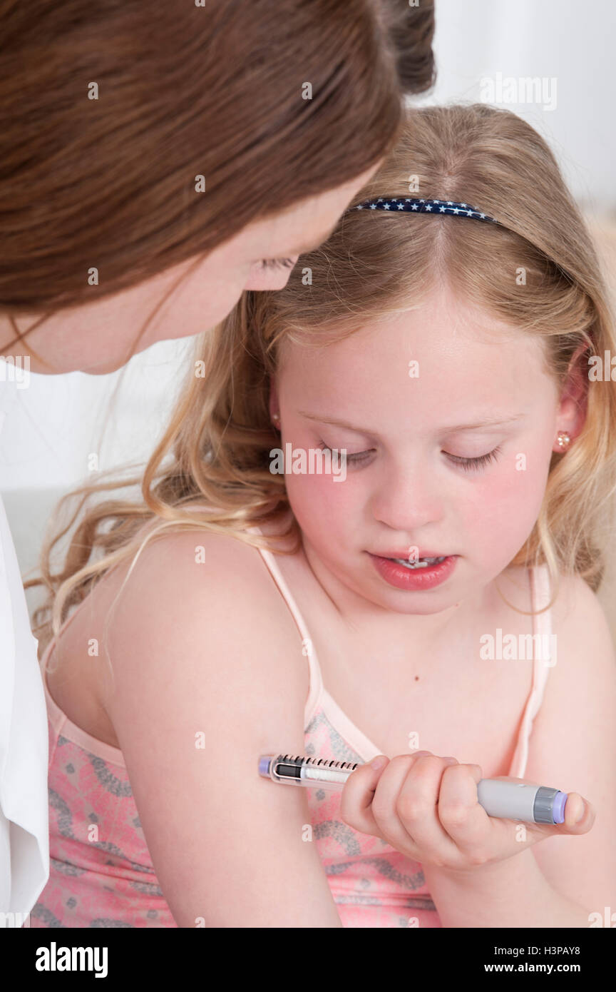MODEL RELEASED. Girl injecting herself in arm with woman watching. Stock Photo