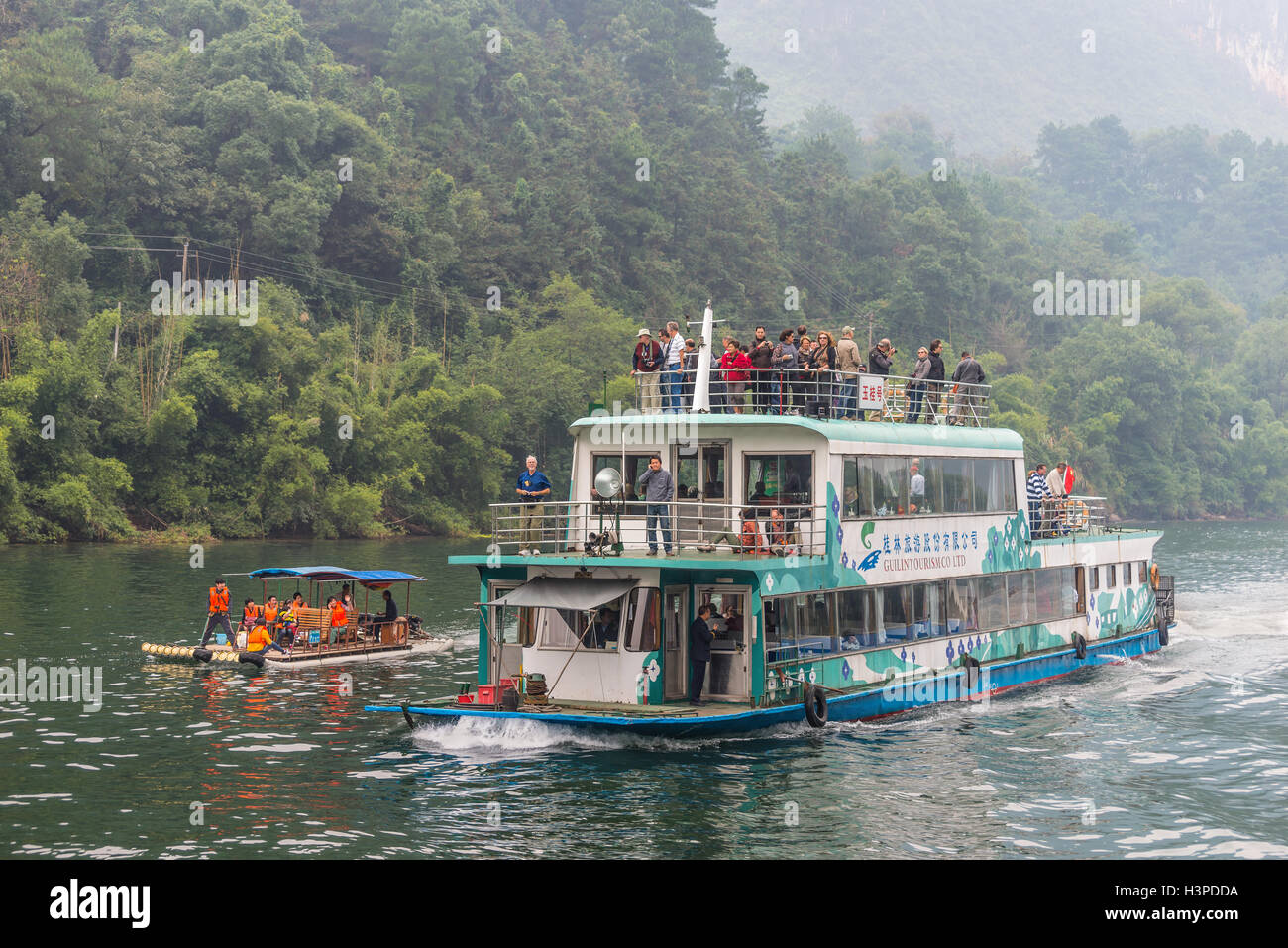 A tourist boat packed with tourists travels the magnificent scenic route along the Li river Stock Photo