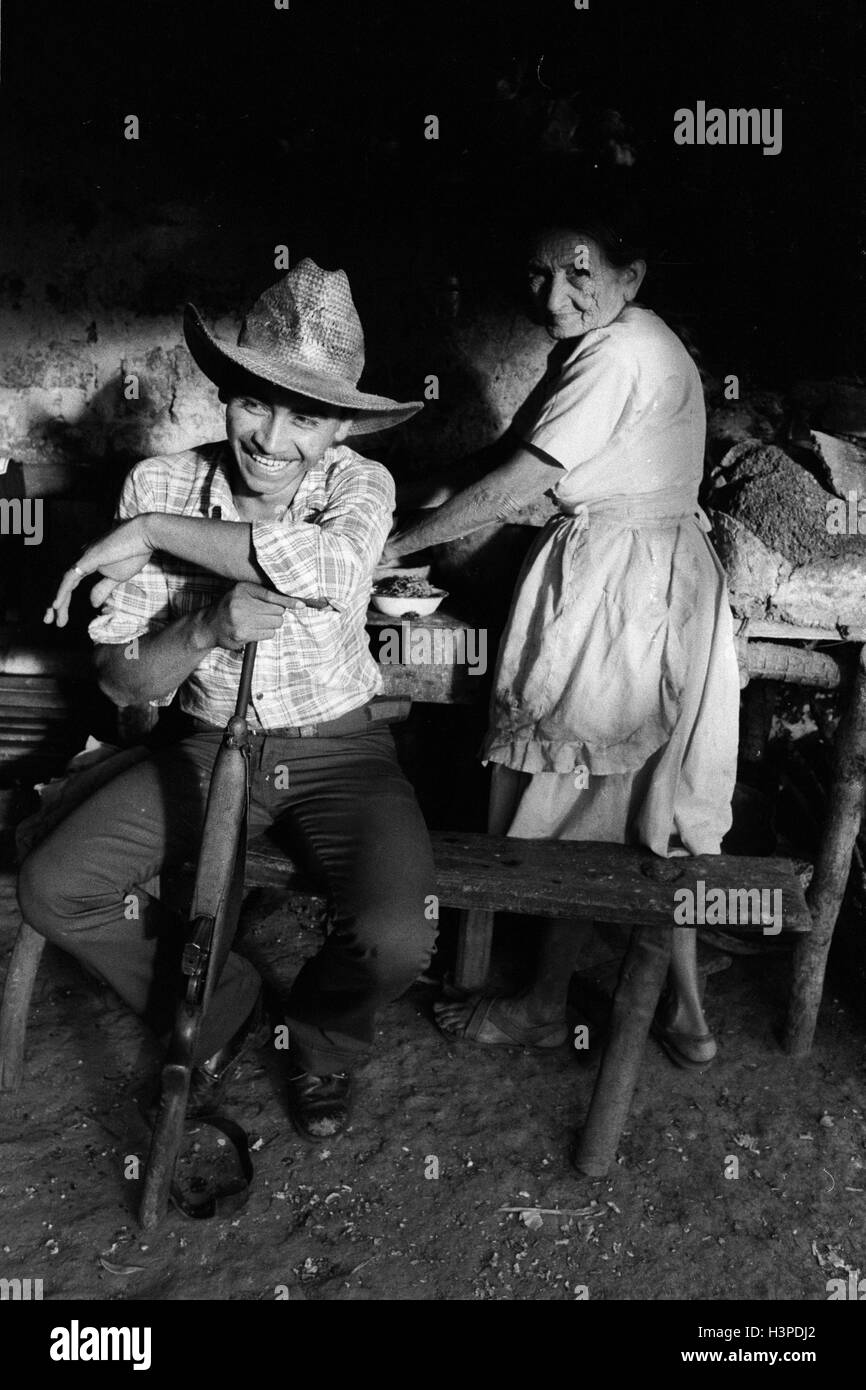 CHALATENANGO,  EL SALVADOR, FEB 1984: - Within the FPL Guerrilla's Zones of Control   A member of the PPL militia in his mother's kitchen Stock Photo