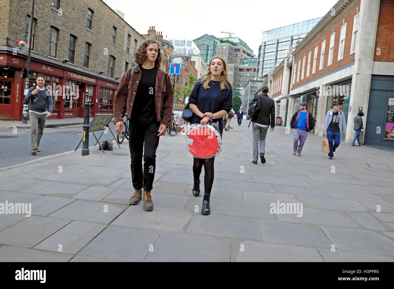 Young people walking along Brushfield Street near Spitalfields Market, East London, UK  KATHY DEWITT Stock Photo