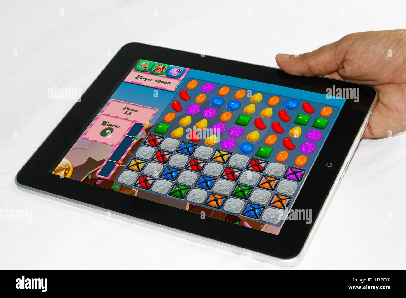A man holding the iPad with candy crush saga game Stock Photo