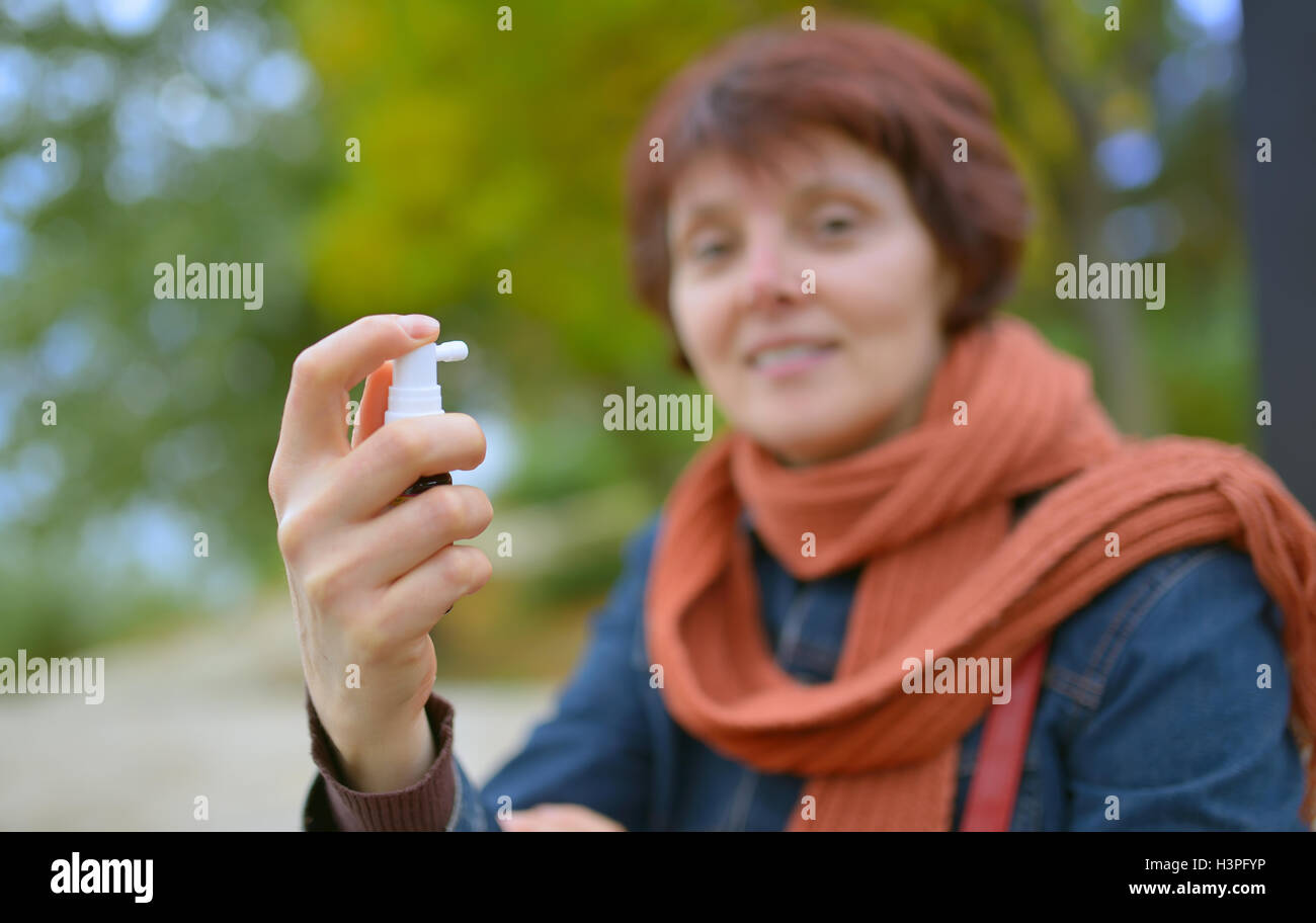 Young woman using throat spray in cold season Stock Photo