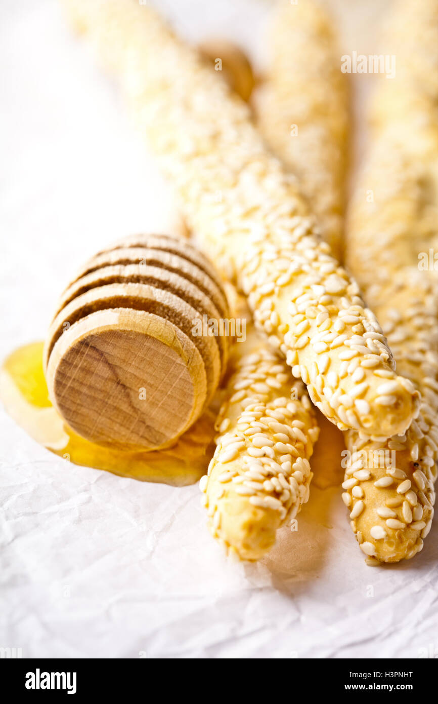 grissini with sesame seeds and honey dipper Stock Photo Alamy