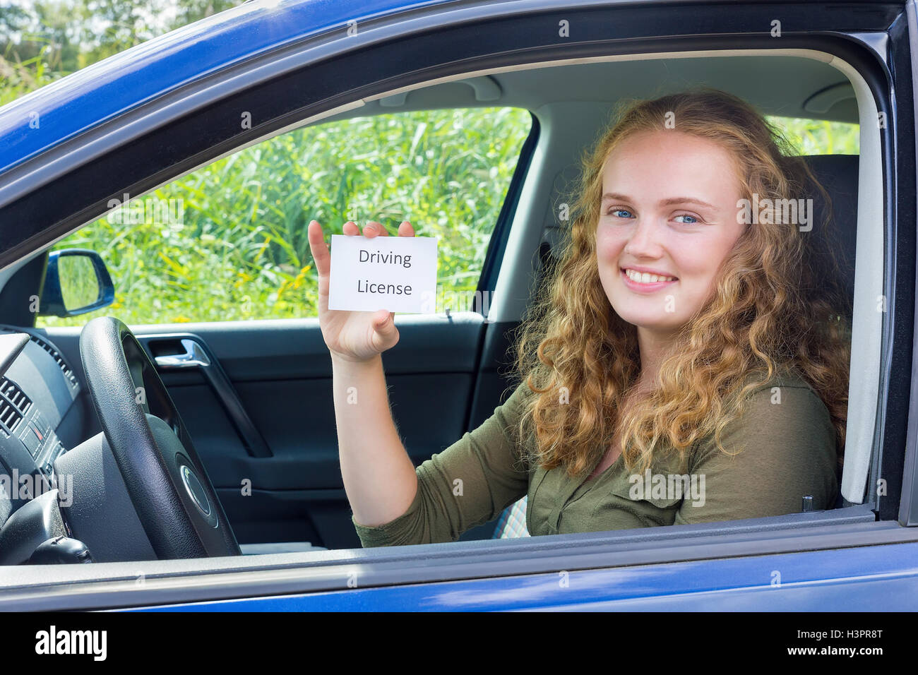 Young european woman showing card driving license in car Stock Photo