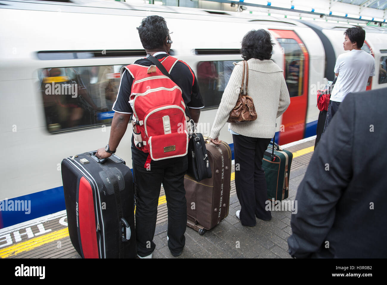 Tourists heavily loaded down with luggage baggage about to board a London Tube  underground train,train station,luggage,London,England. U.K.,Europe Stock  Photo - Alamy