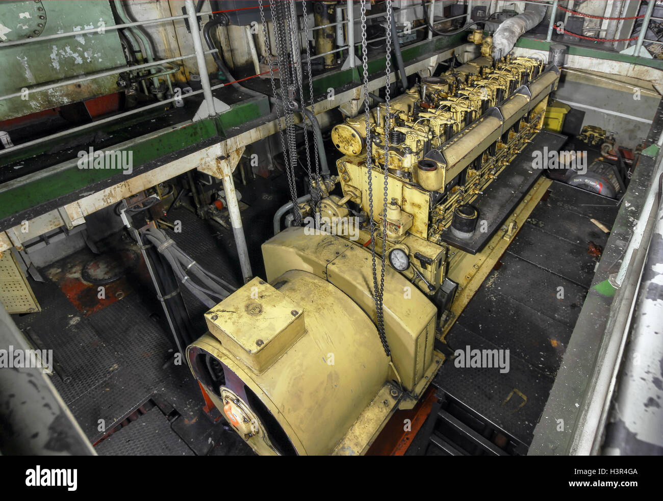 Yellow engine mounted on ship. Engine room on a old cargo boat ship. Stock Photo