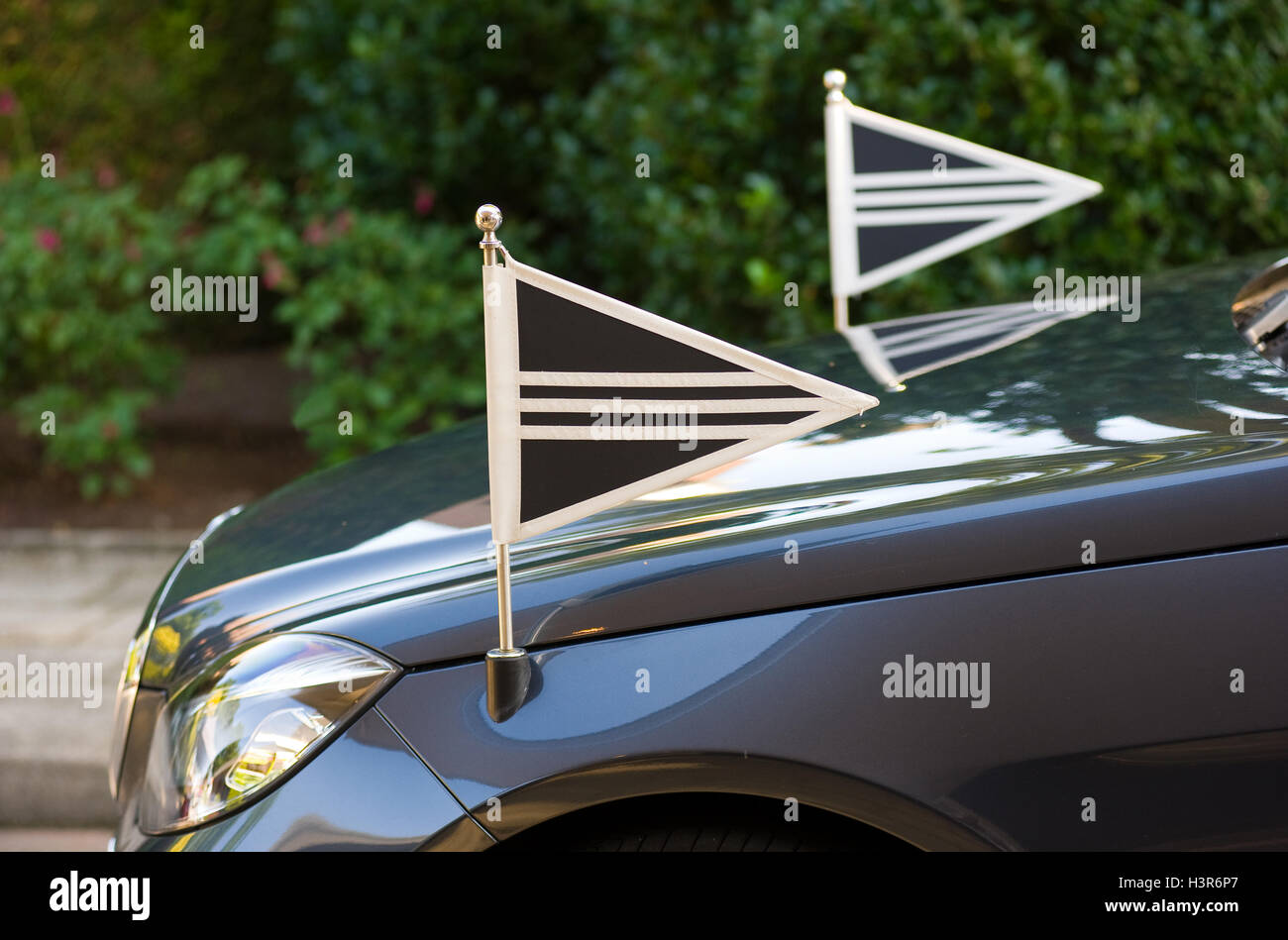 Two little flags on the front of a mourning car Stock Photo