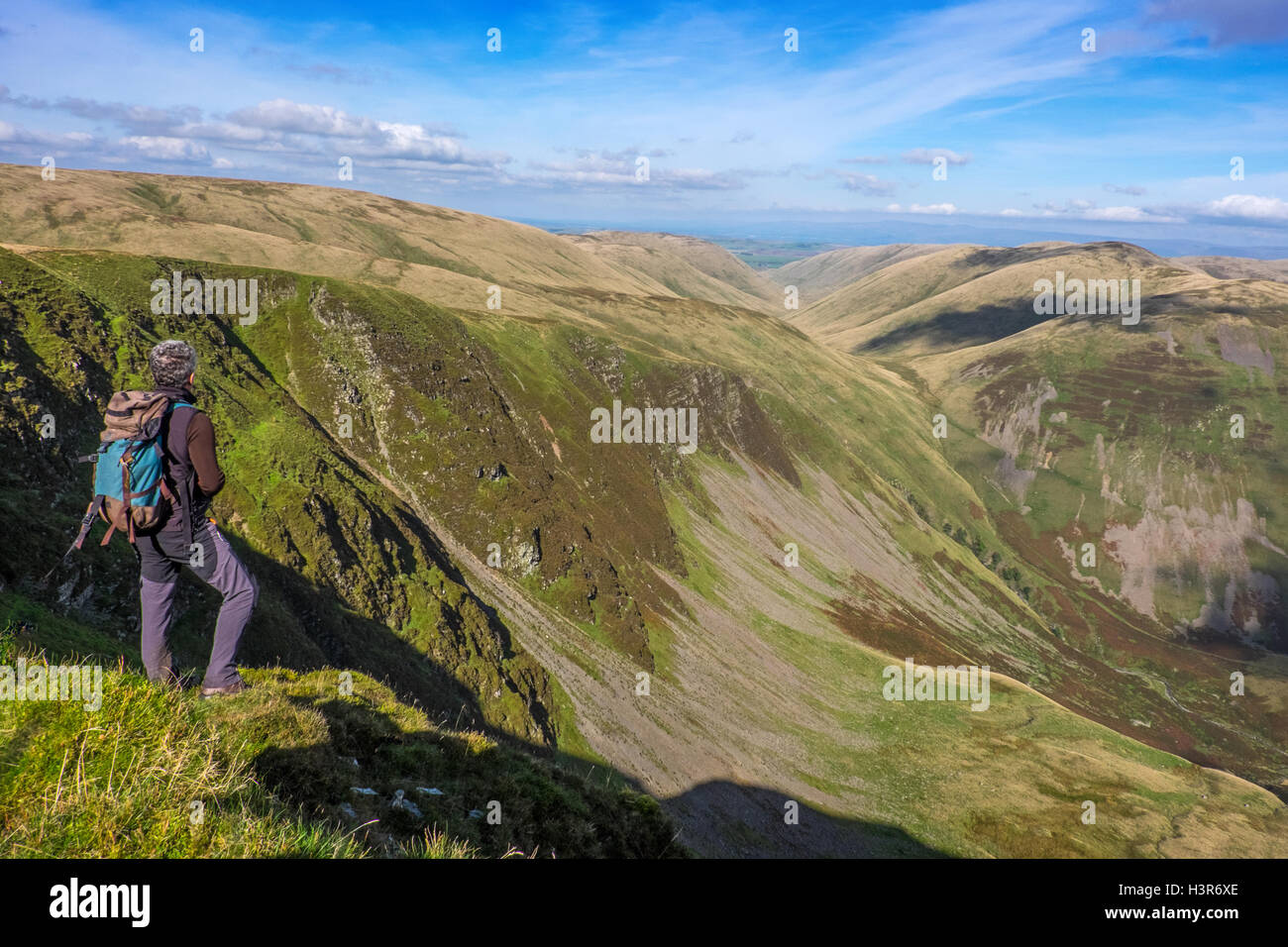 A hill walker Looking towards Cautley Spout from Great Dummocks in the Howgills Stock Photo