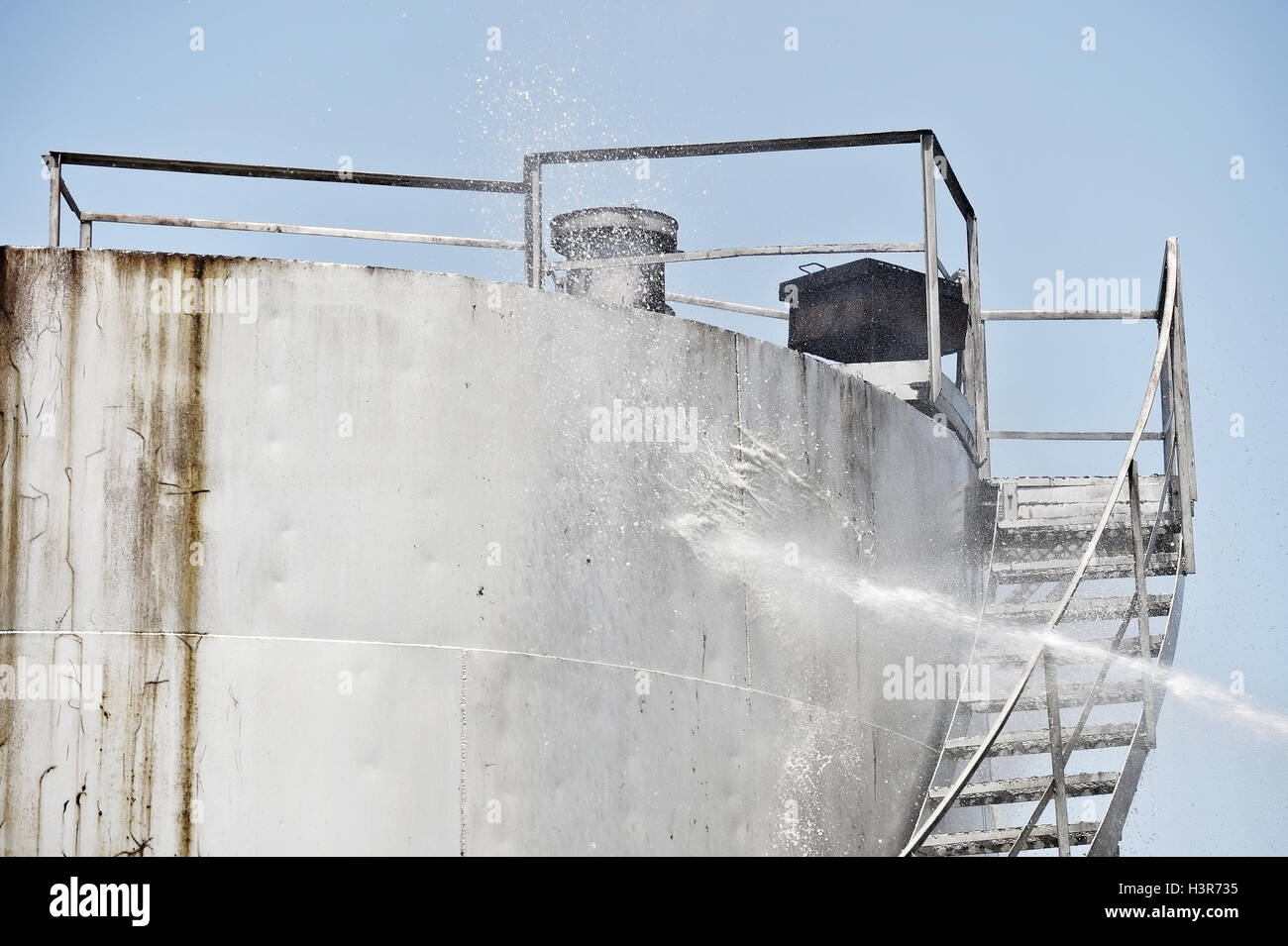 Firefighter water jet extinguish the fire started near a petrol storage tank Stock Photo Alamy