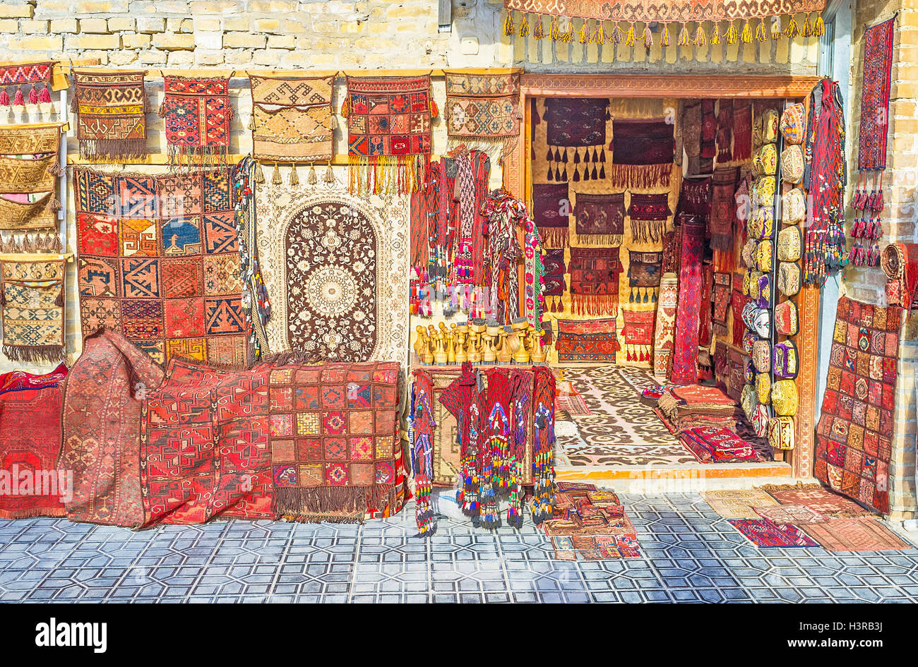 The wide range of the hand made carpets in traditional style in the small stall at Toqi Sarrafon bazaar in Bukhara. Stock Photo