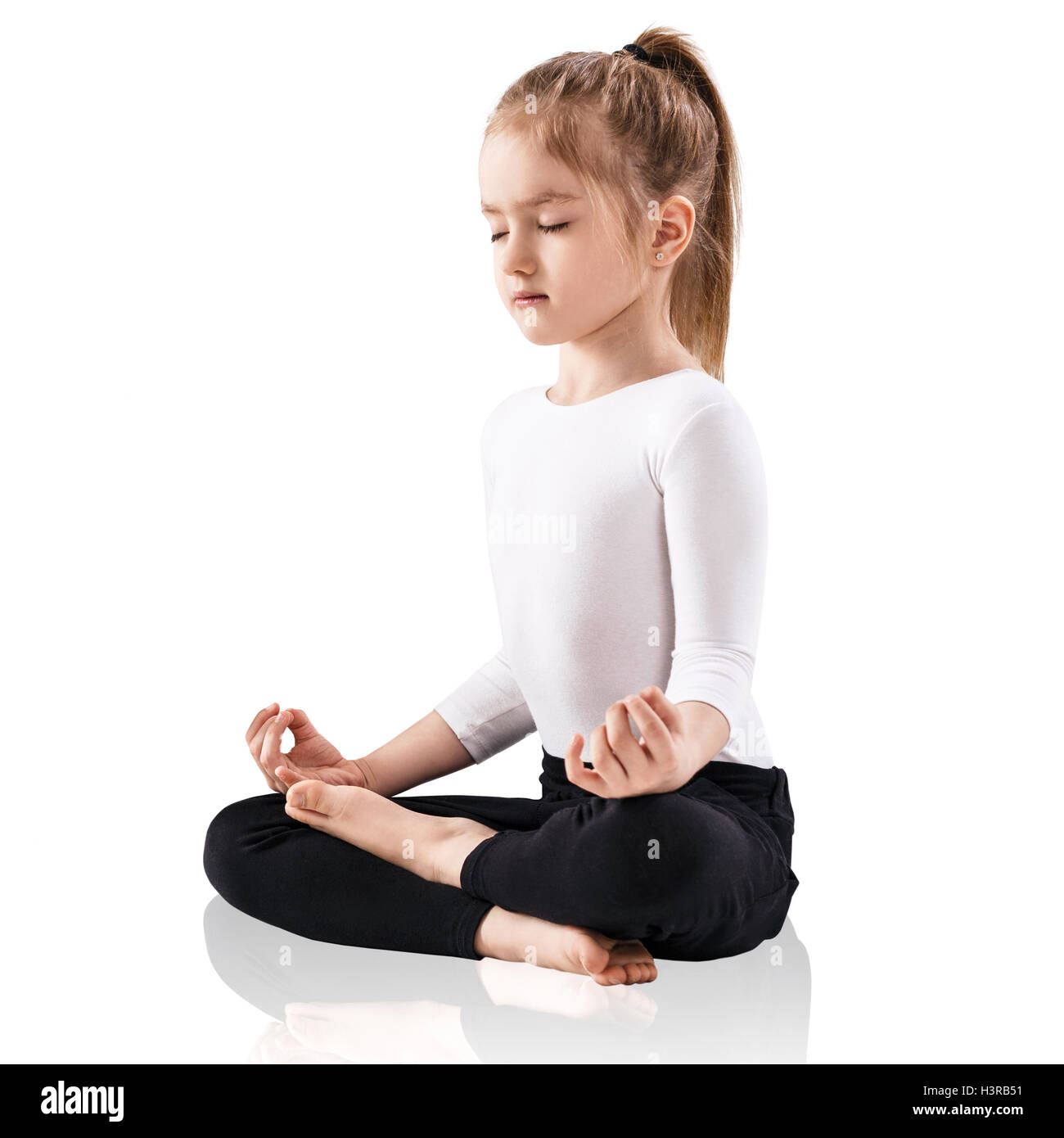 Little girl meditating in lotus position Stock Photo