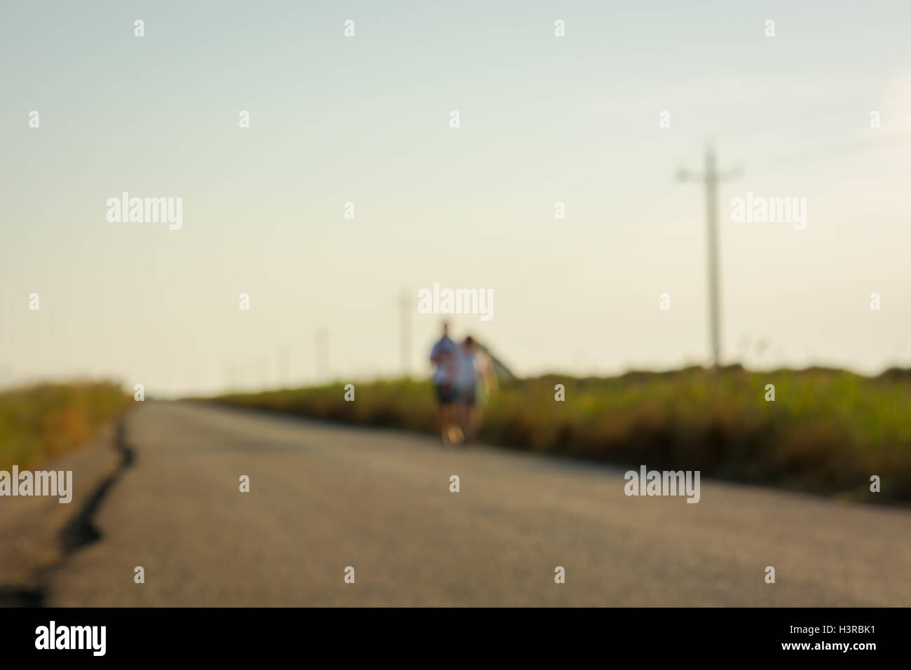 Unfocused people walking along a country road. Stock Photo