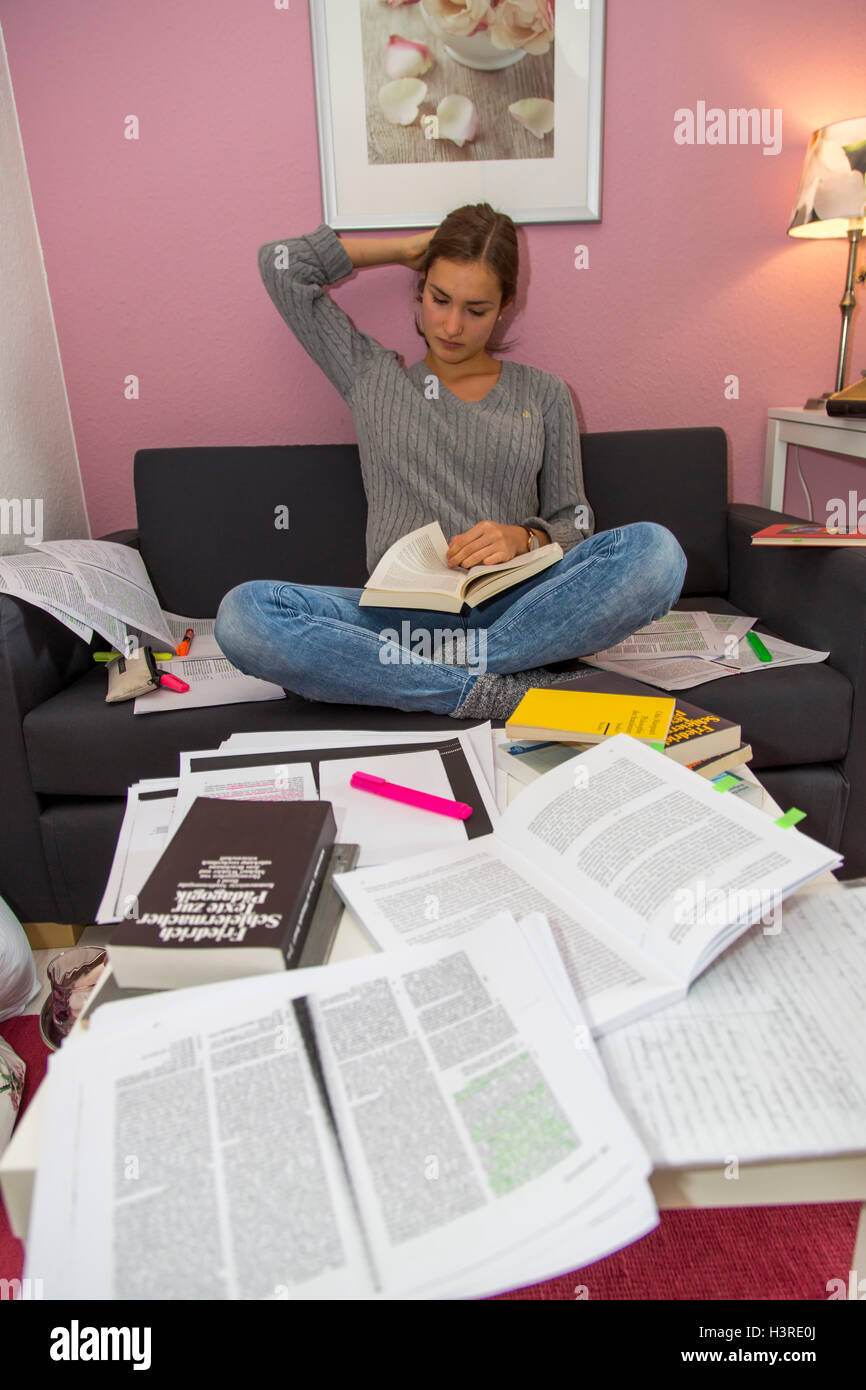Female student is working in her student apartment, for a examination, test, Stock Photo