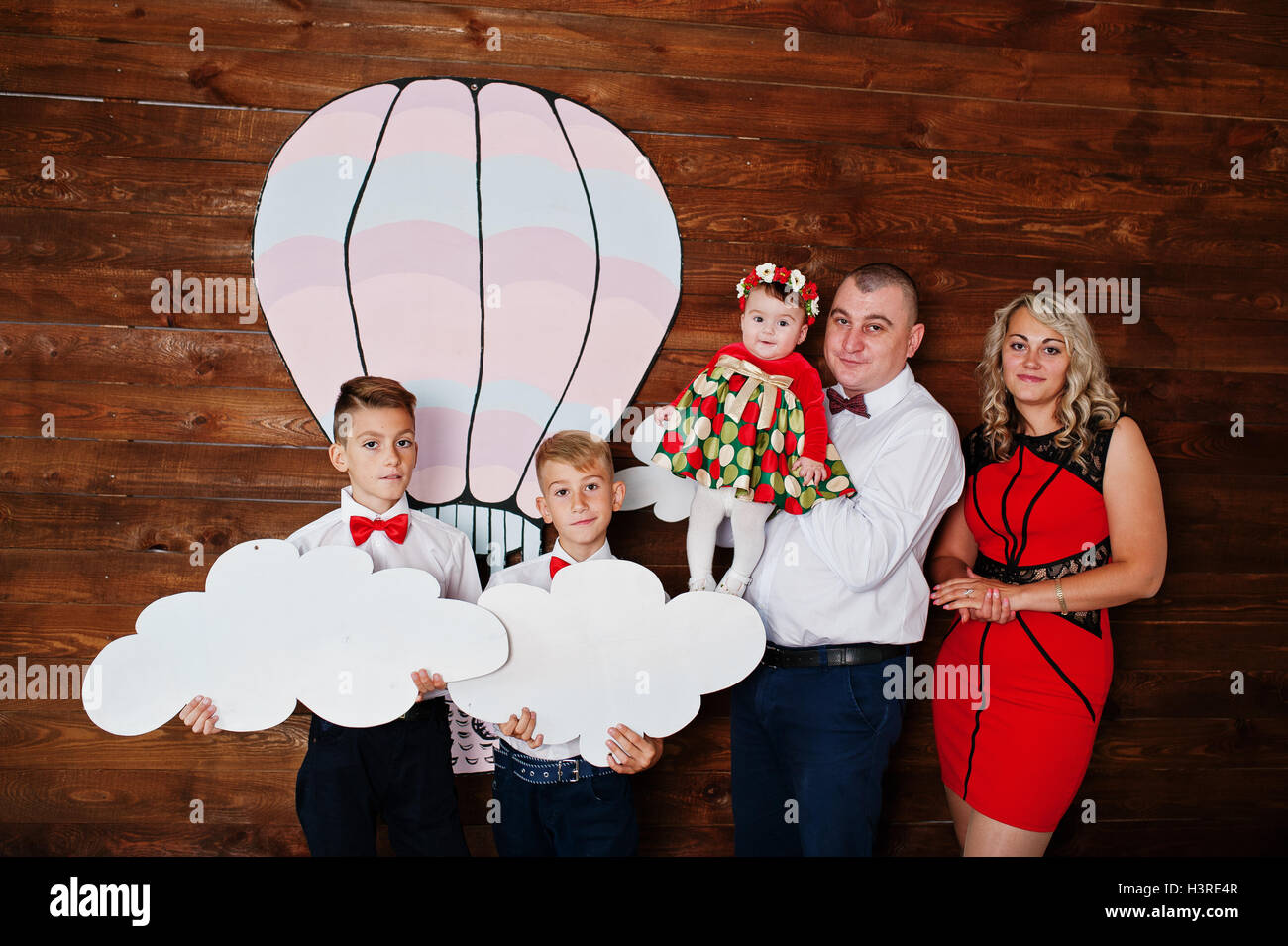 Caucasian family posed in vintage studio room background wooden wall