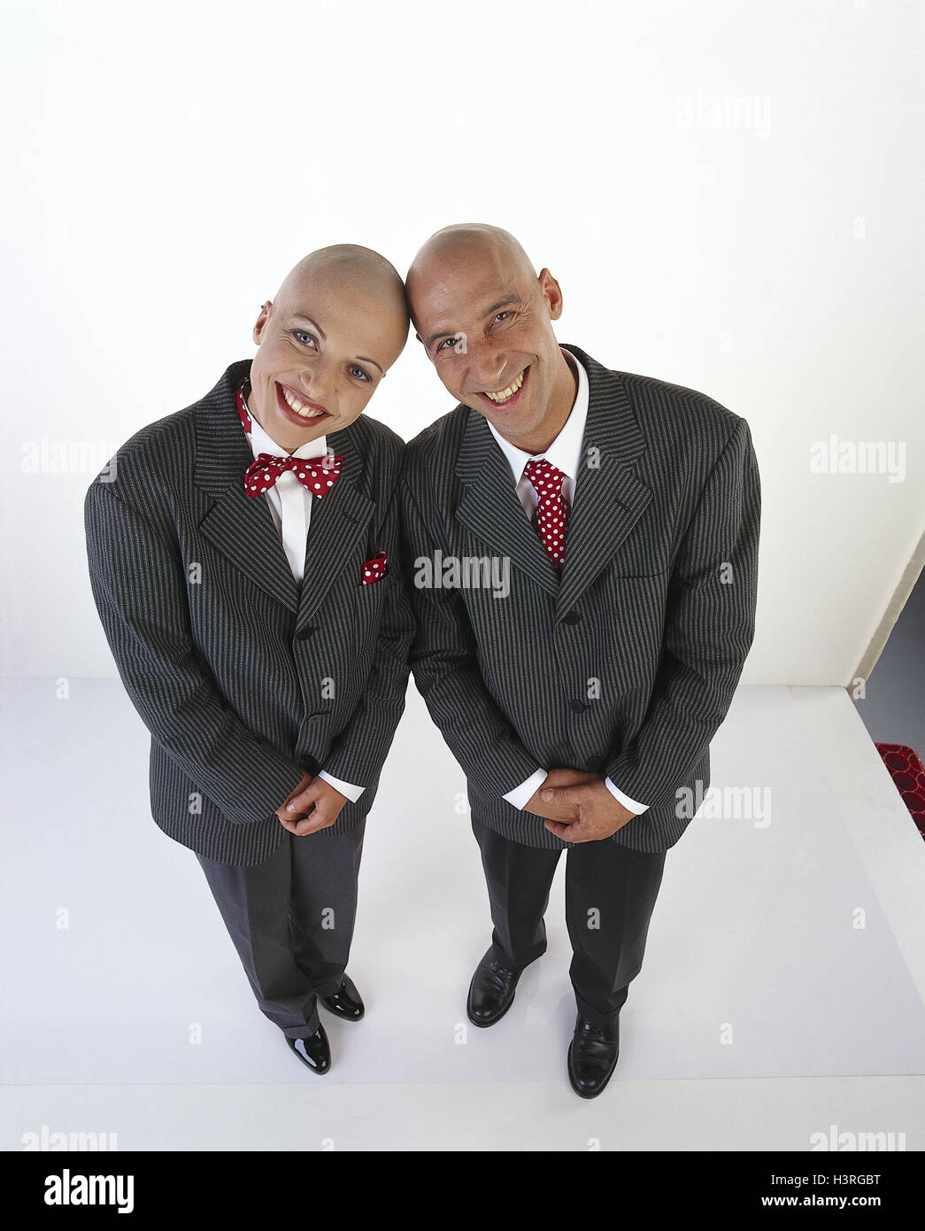 Couple, bald head, suit, smile pinstripe suit, partner's look, stand, inside, studio, cut out, from above Stock Photo