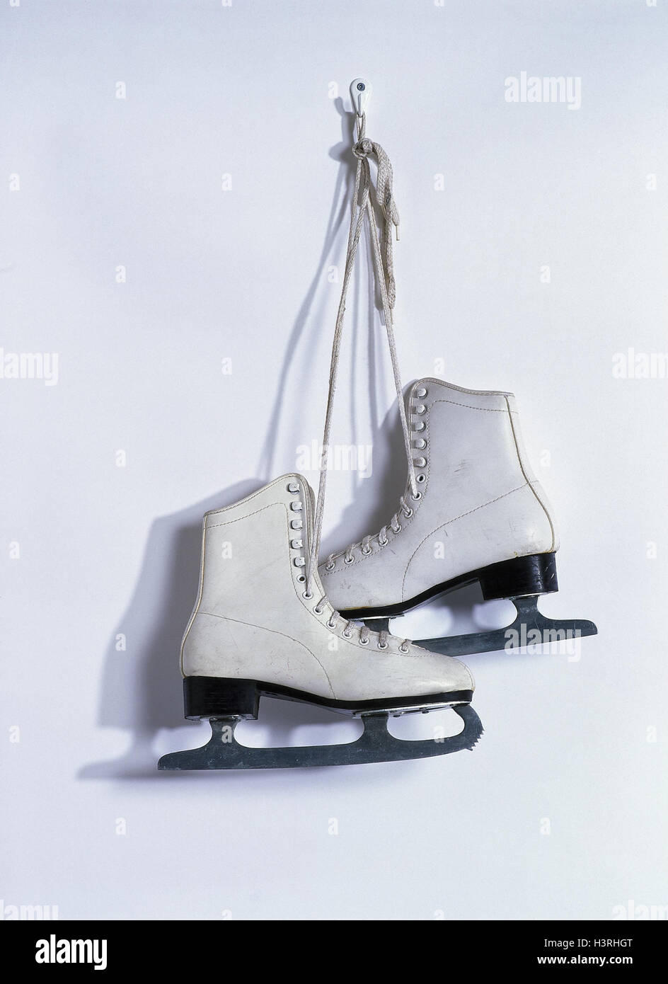 Wall, hook, ice skates, white skating shoes, sport, skating, go skating, 'give up', leisure time, hobby, winter sports, product photography, stilllife, studio Stock Photo