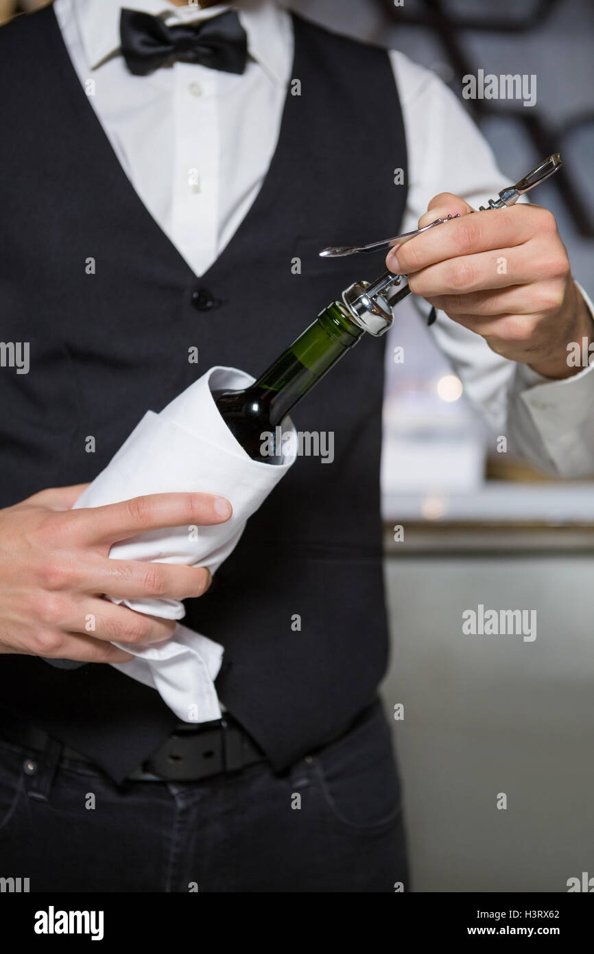 Bartender using corkscrew to open wine bottle Stock Photo Alamy