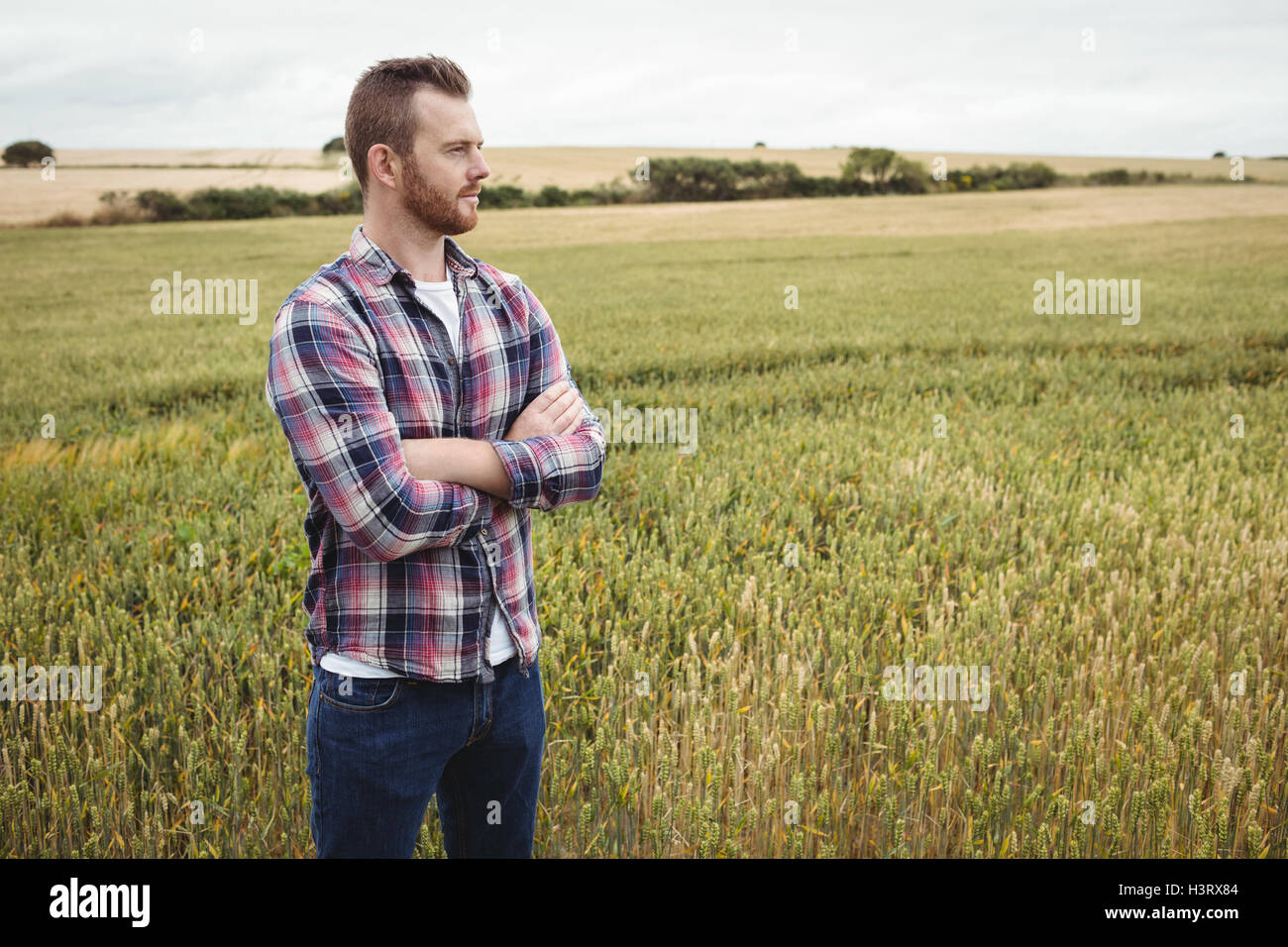 Portrait of farmer standing with arms crossed in the field Stock Photo ...