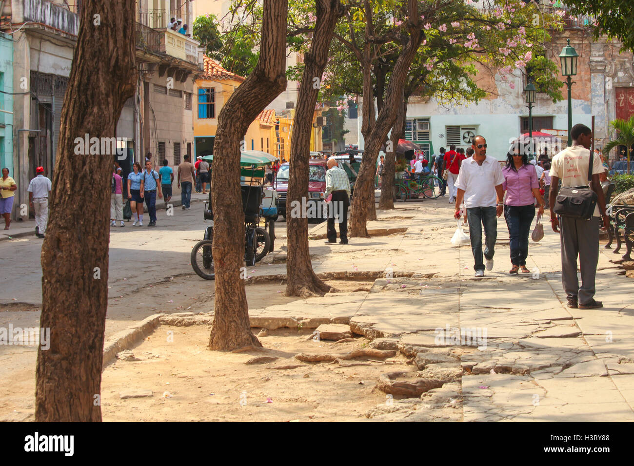 People walking in a street with holes in it in the center of Havana, Cuba Stock Photo