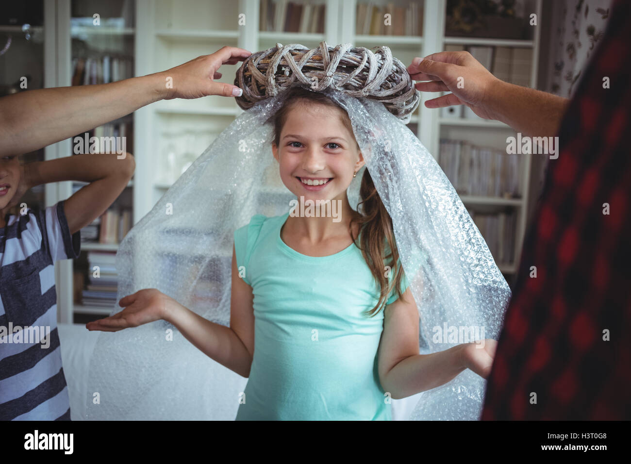 Girl imitating to be an angel by wearing a bubble wrap and an unpacked ring Stock Photo