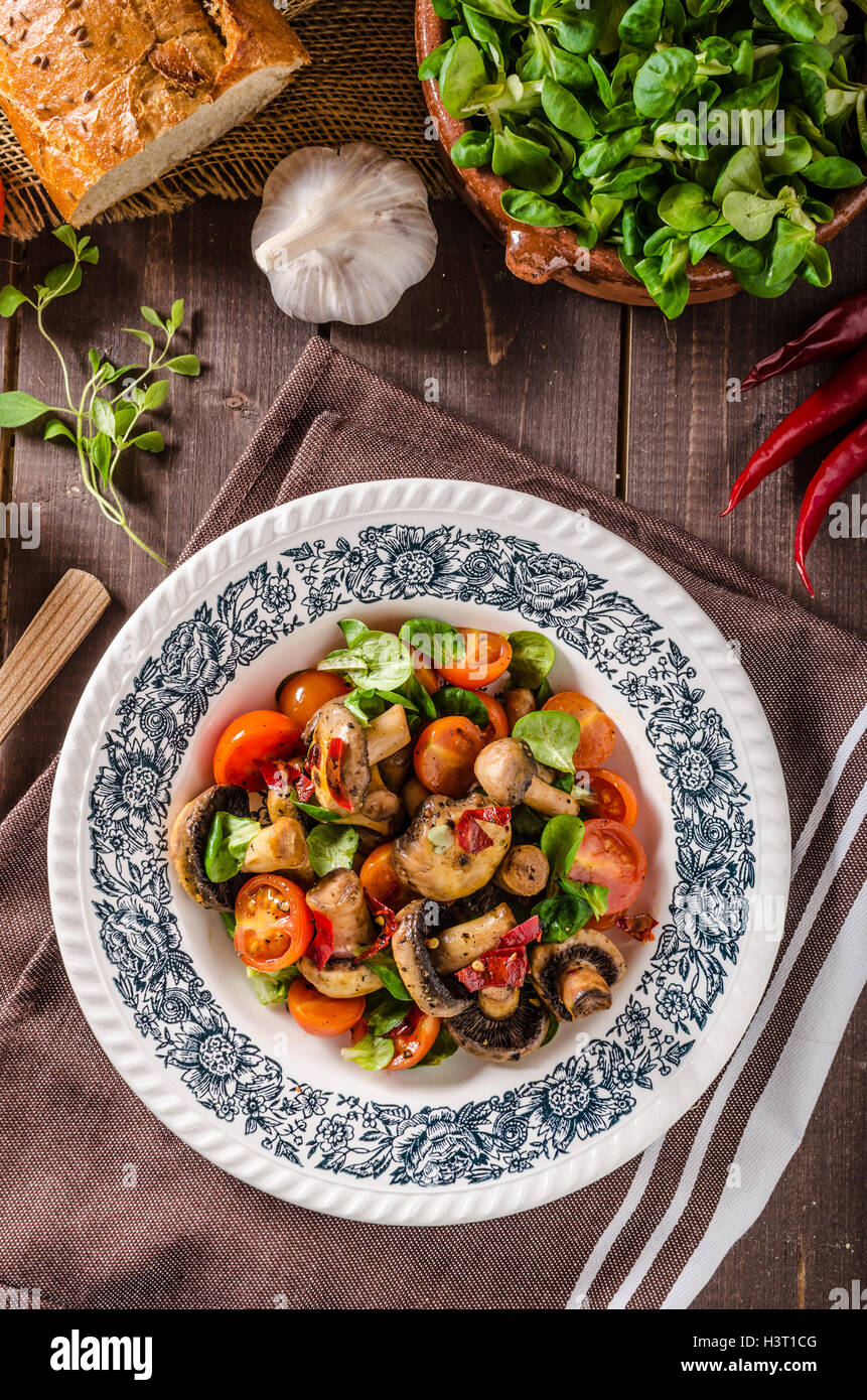 Warm mushroom salad with chilli and tomatoes Stock Photo
