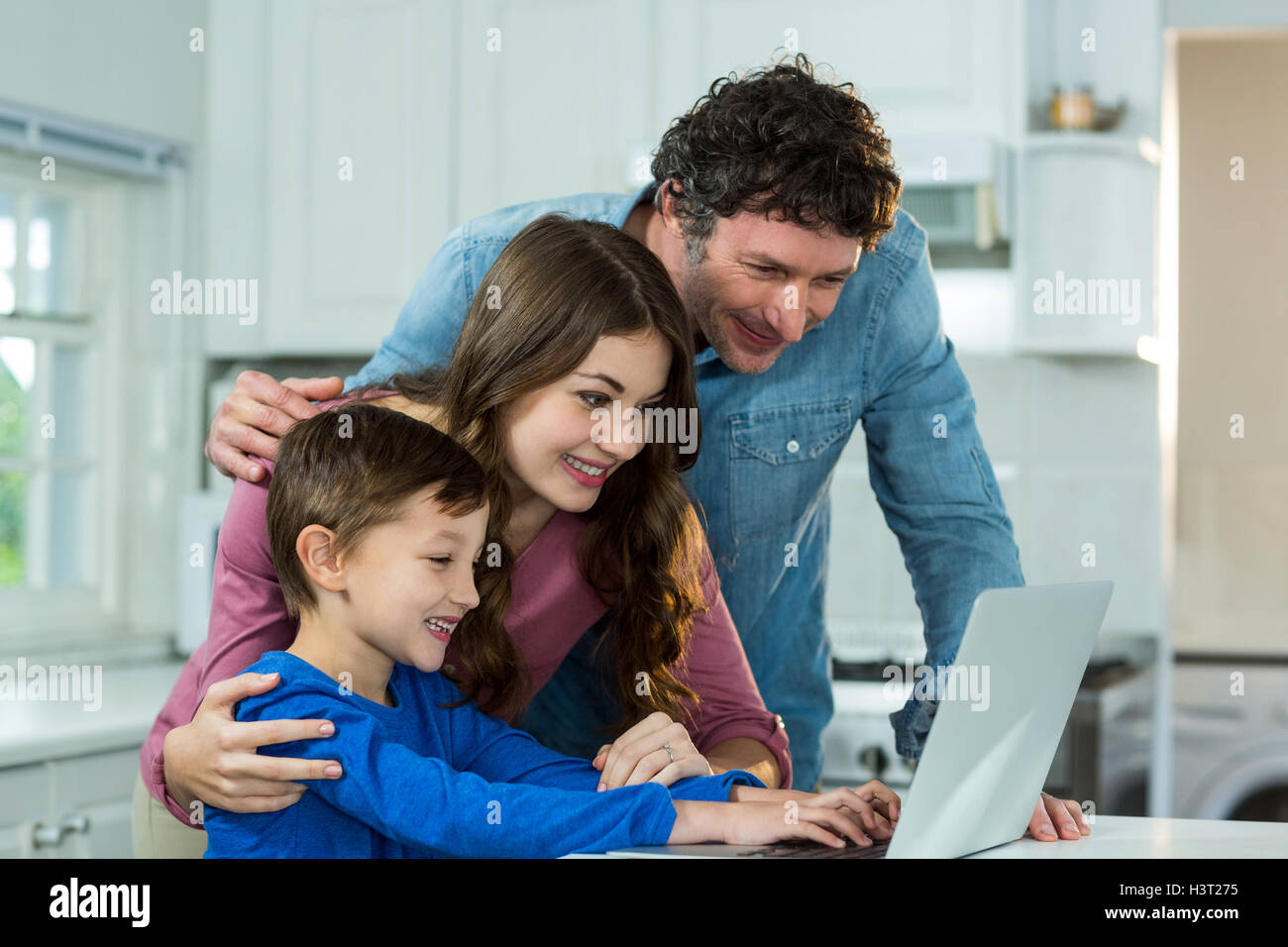 Happy family using laptop Stock Photo - Alamy