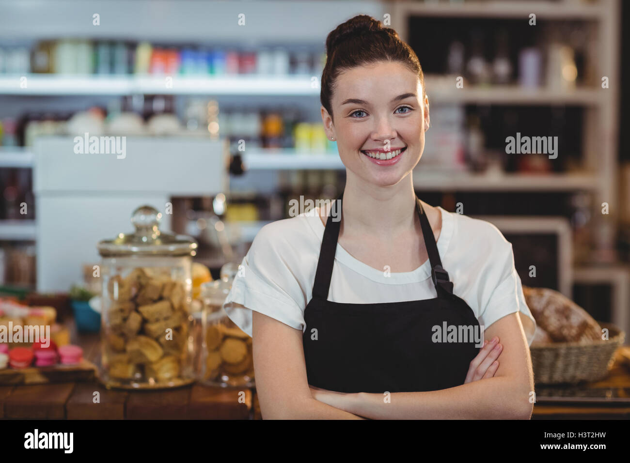 Portrait of smiling waitress standing with arms crossed Stock Photo - Alamy