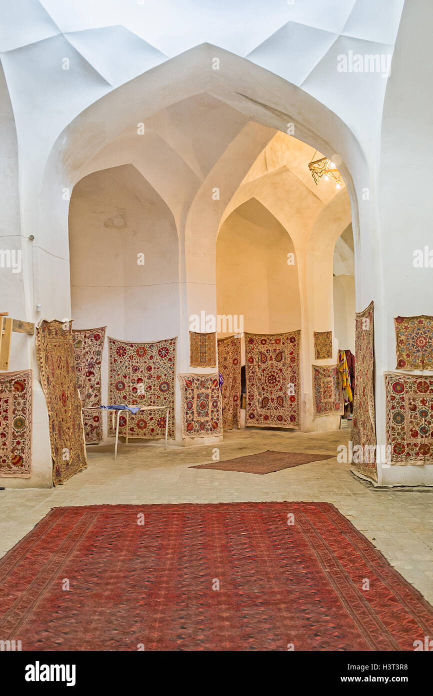 The rug store with the wide range traditional carpets and embroidered tablecloths in Bukhara. Stock Photo