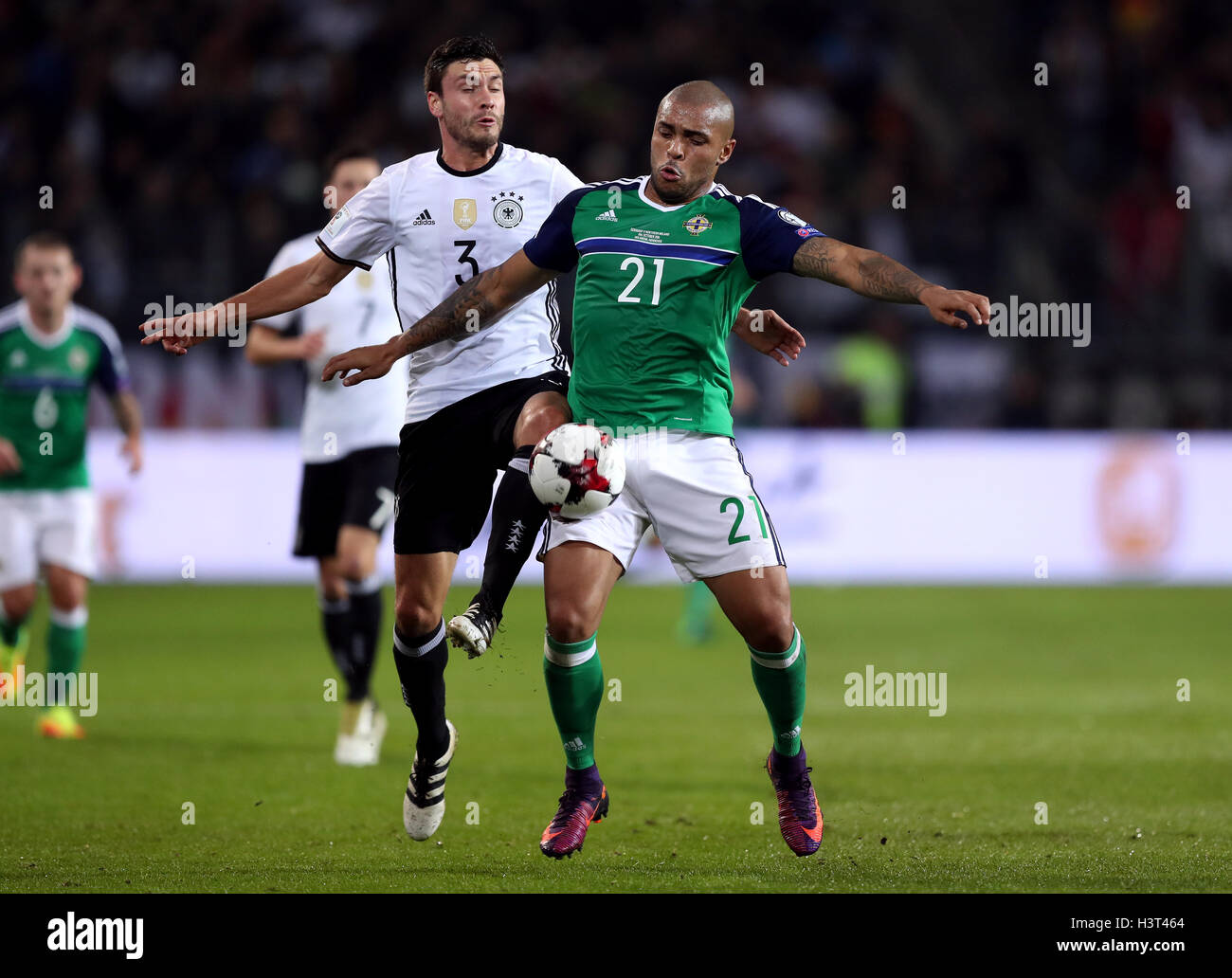 Germany's Jonas Hector (left) and Northern Ireland's Josh Magennis battle for the ball during the 2018 FIFA World Cup Qualifying match at the HDI Arena, Hannover. Stock Photo