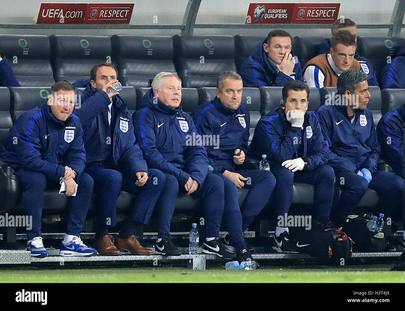 England's interim manager Gareth Southgate (second left), assistant coaches Steve Holland (left) and Sammy Lee (third right) and Wayne Rooney (back left) and Jamie Vardy (back right) in the dugout during the 2018 FIFA World Cup Qualifying match at the Stozice Stadium, Ljubljana. Stock Photo