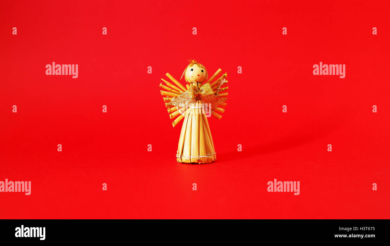 Straw angel with a red background Stock Photo - Alamy