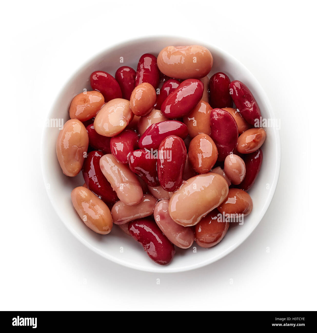 Various types of canned beans in bowl isolated on white background, top