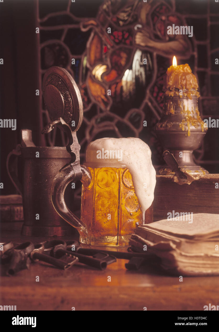 Beer mug, served book, key bundle, burning candle Stock Photo