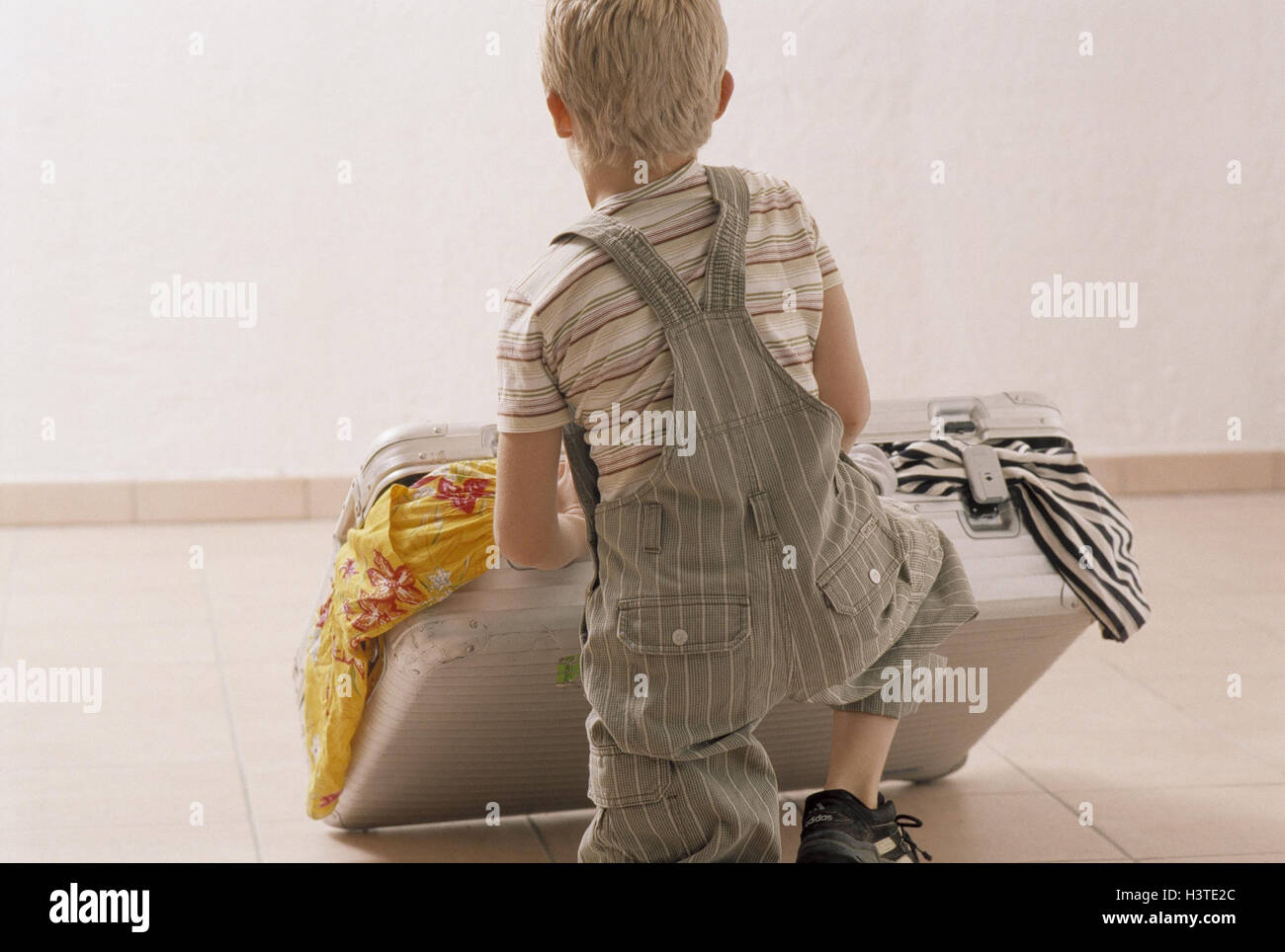 Boy, suitcases pack, back view, go away inside, child, to suitcase stacks, to travel, suitcase, luggage, overcrowds, completely, clothes, clothes pieces, pack, lonely, only, vacation, holidays, prejoy, independence Stock Photo