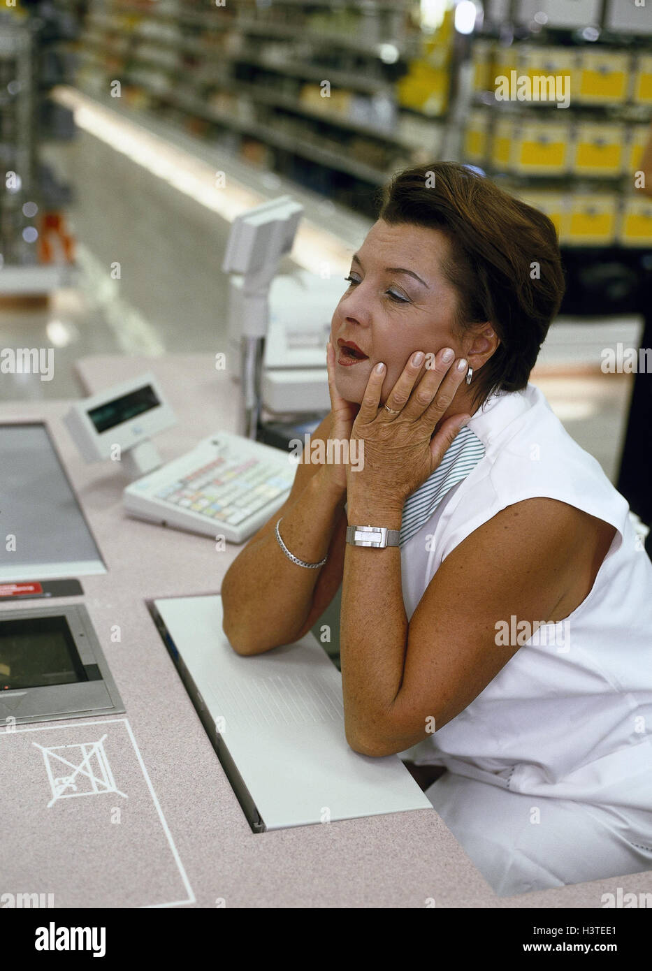 Supermarket, cashier, gesture, fatigue, depletion, business, retail trade, loading, cash box, consumption, pay, take the money, shopping, woman, occupation, shop assistant, inattentively, absently, reworks, tiredly, exhausted, disinterest, listlessness, b Stock Photo