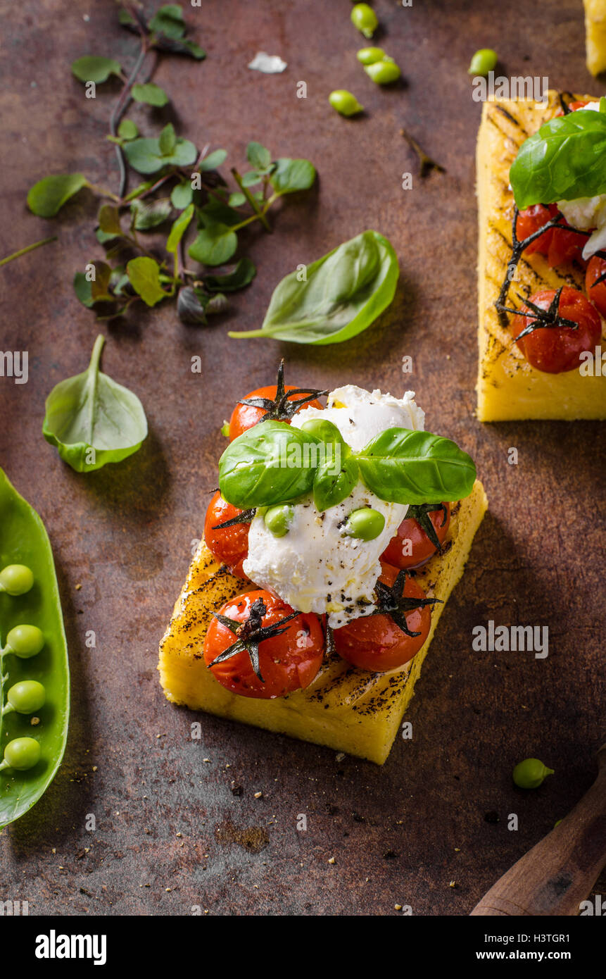 Grilled polenta with roasted tomatoes and creamy goat curd Stock Photo Alamy