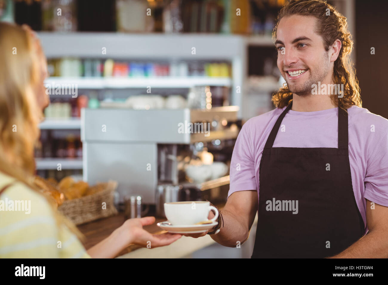 Waiter serving a cup of coffee at counter Stock Photo Alamy