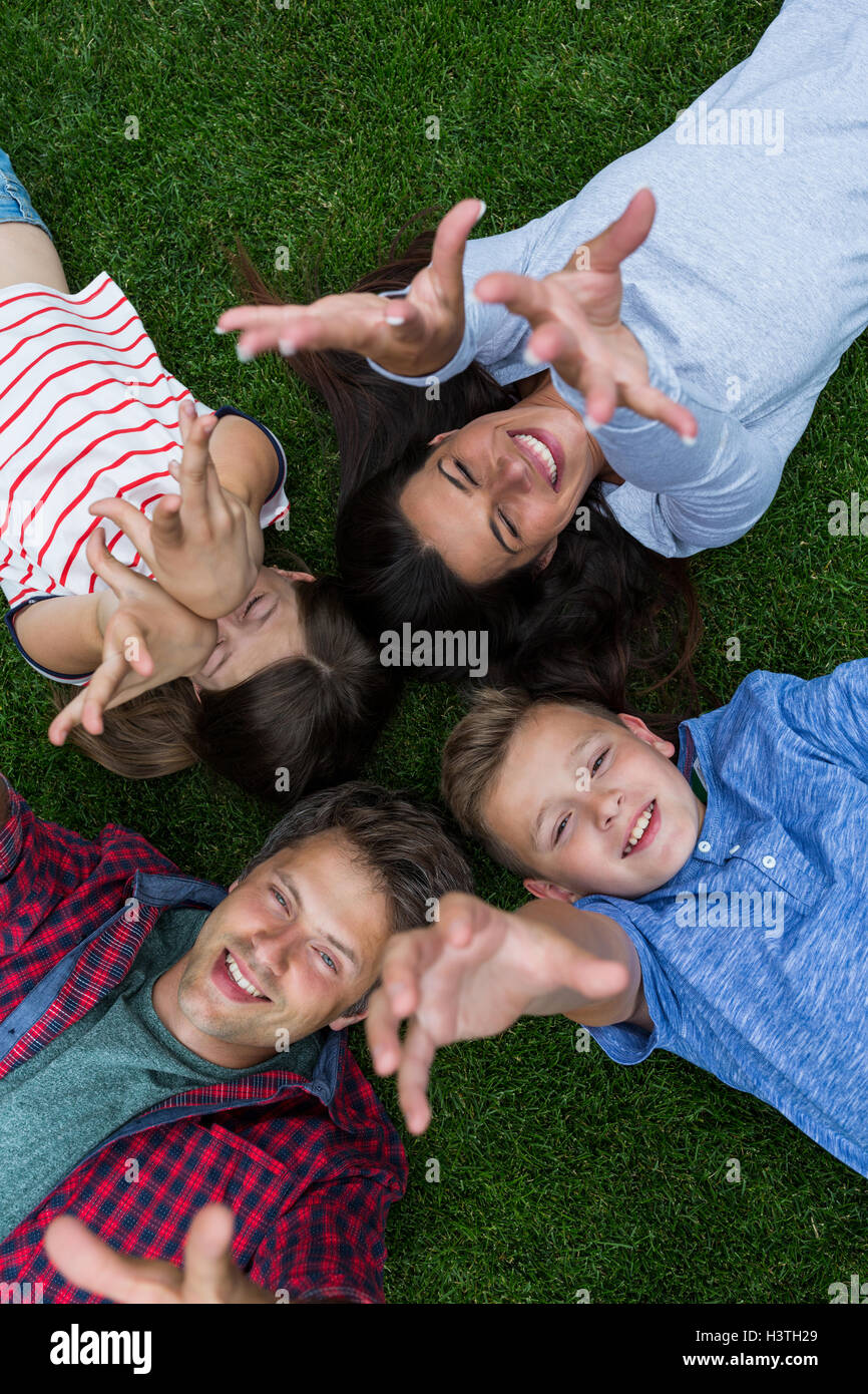 Happy family lying on grass in park Stock Photo - Alamy