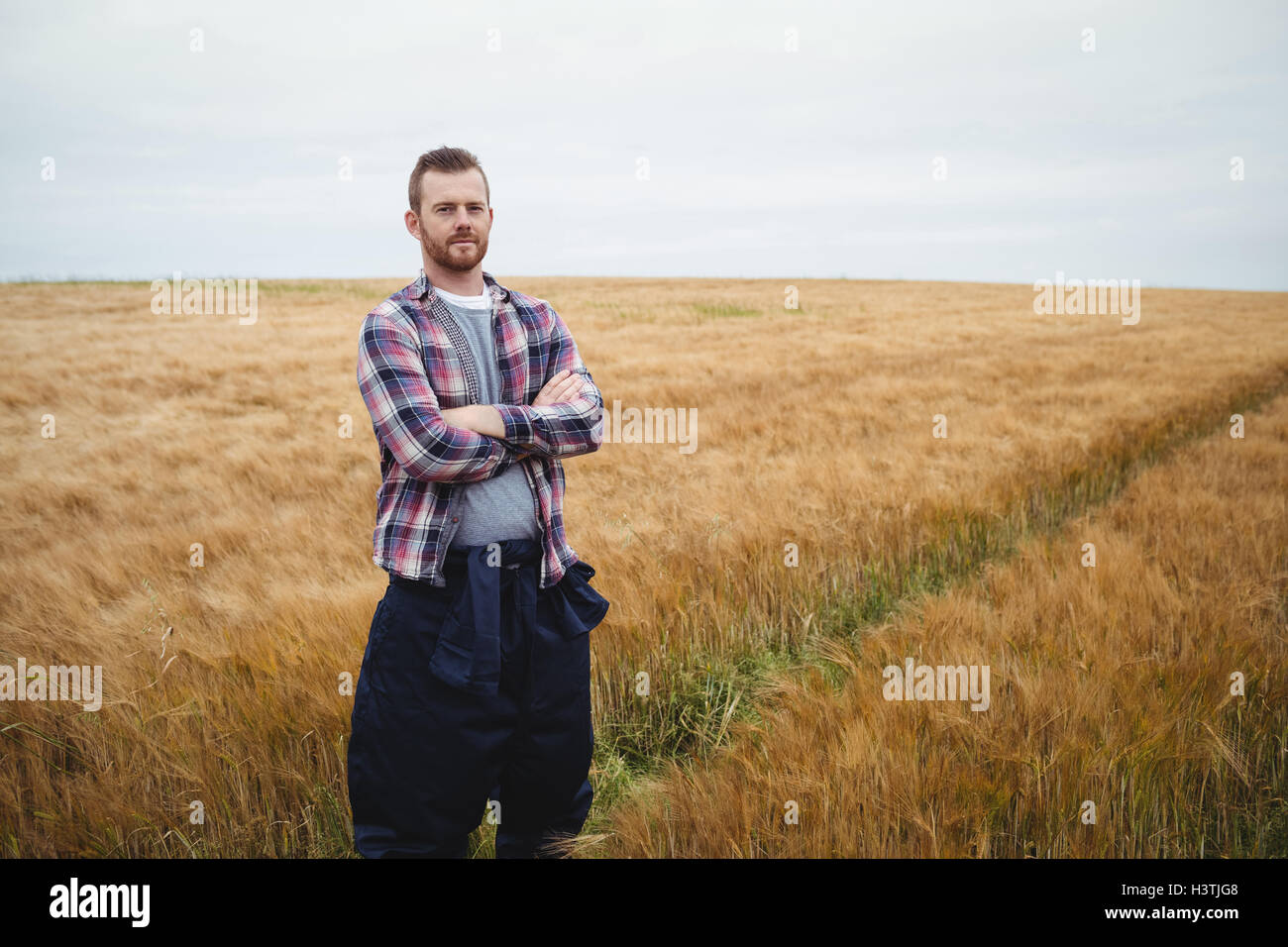 Portrait of farmer standing with arms crossed in the field Stock Photo ...