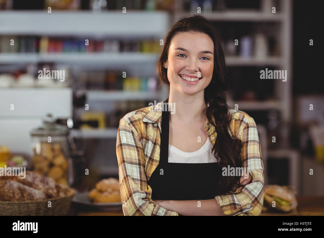Portrait of smiling waitress standing with arms crossed Stock Photo - Alamy