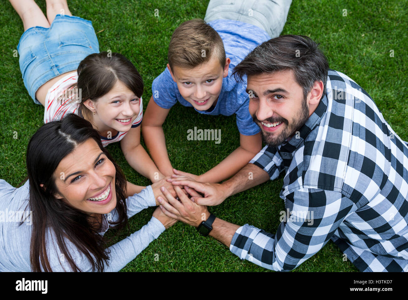 Happy family lying on grass in park on a sunny day Stock Photo - Alamy