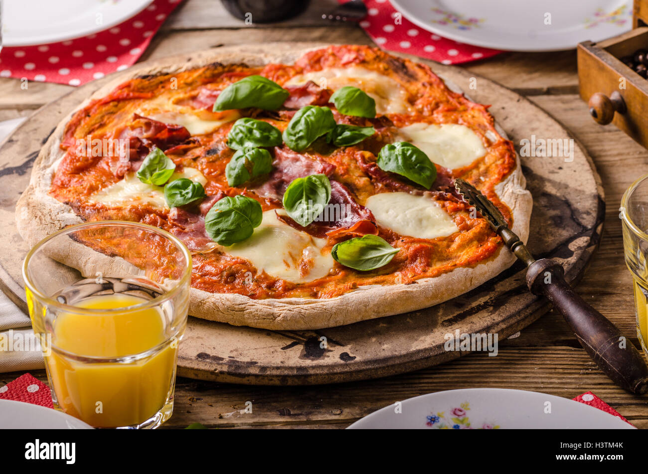Rustic Italian pizza margherita with prosciutto and basil Stock Photo