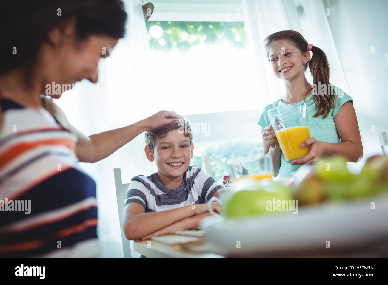 Smiling family having a breakfast Stock Photo - Alamy